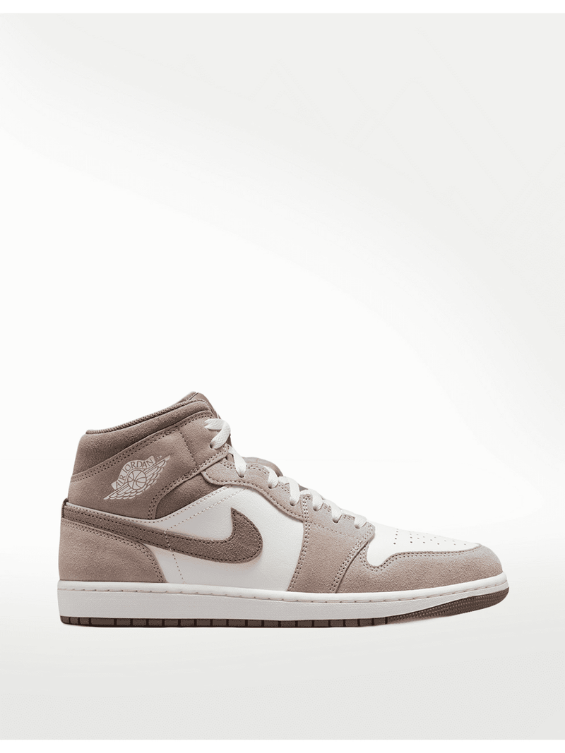 Zapatillas Air Jordan 1 Mid SE de gamuza y cuero en taupe y blanco, con logo Wings y Swoosh de Nike.
