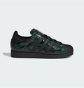 Zapatillas Adidas Superstar con estampado de serpiente en verde y negro, con detalles dorados y puntera de goma.