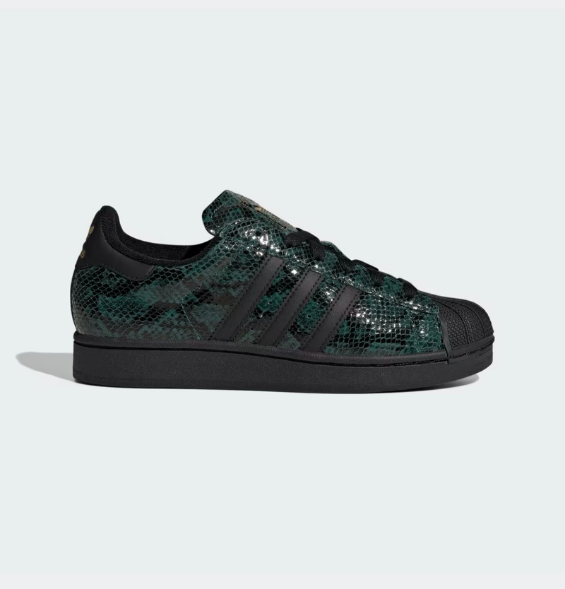 Zapatillas Adidas Superstar con estampado de serpiente en verde y negro, con detalles dorados y puntera de goma.
