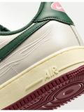 Zapatillas deportivas 𝐋𝐔𝐀𝐋 de cuero blanco y verde con detalles bordados y suela de goma burdeos.