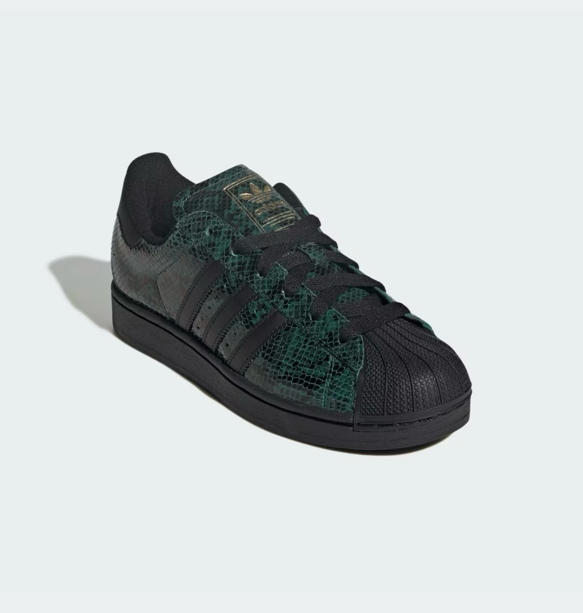 Zapatillas Adidas Superstar con estampado de serpiente en verde y negro, puntera de goma y detalles dorados.