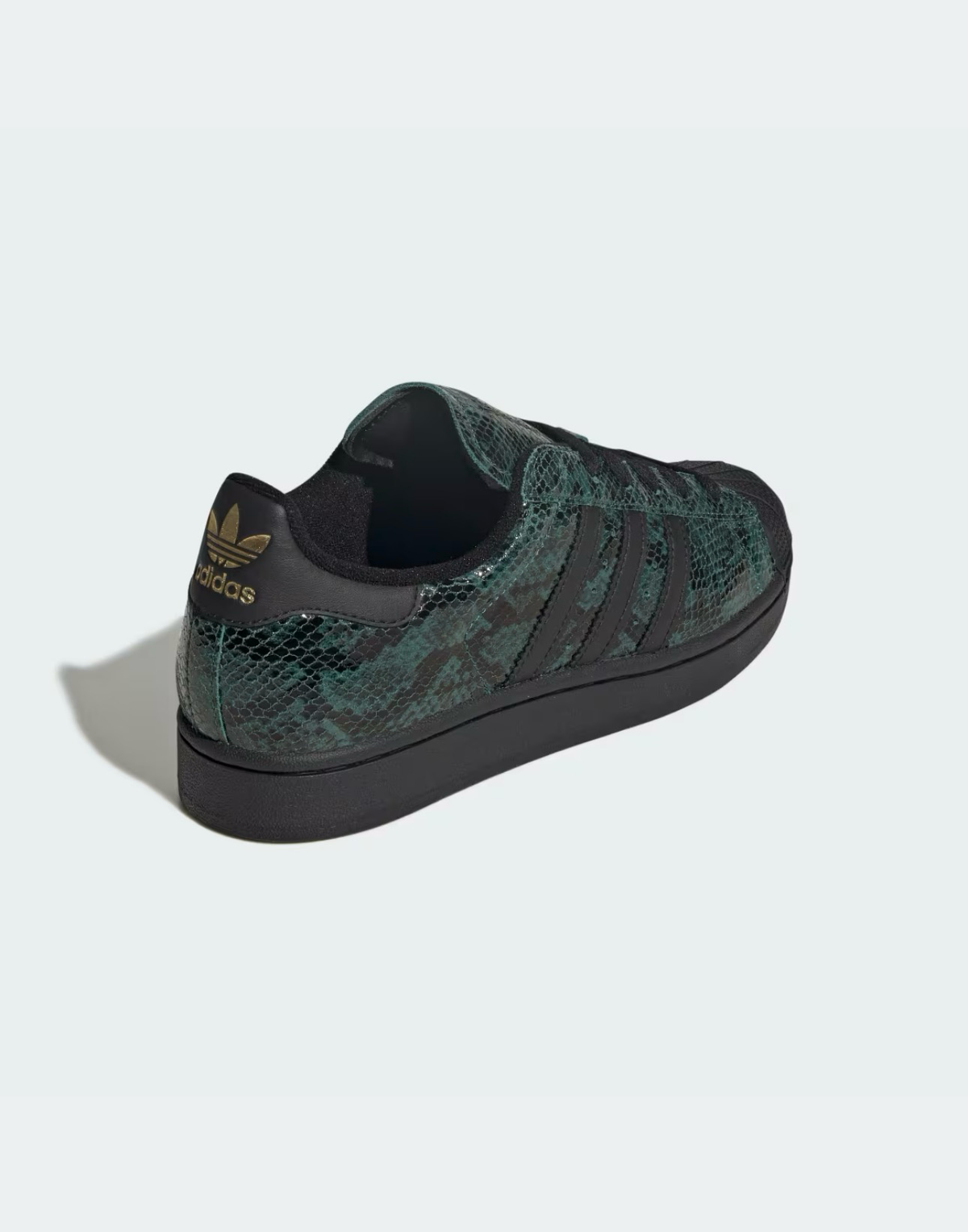 Zapatillas Adidas Superstar con estampado de serpiente en verde y negro, con detalles dorados y puntera de goma.