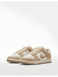 Tenis 𝐋𝐔𝐀𝐋 Nike Dunk Low en tonos arena y crema, fabricados en cuero y gamuza con detalle de Swoosh metálico dorado.