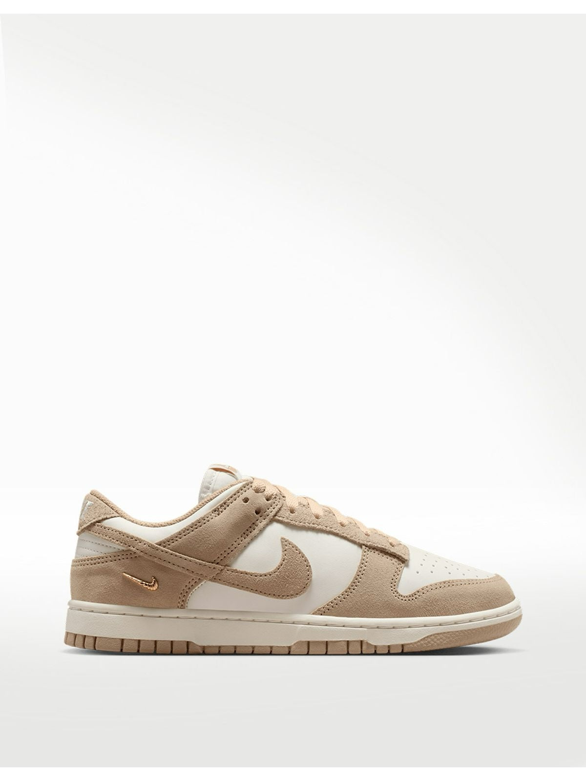 Tenis 𝐋𝐔𝐀𝐋 Nike Dunk Low en tonos arena y crema con cuero, gamuza y detalle de Swoosh metálico dorado.