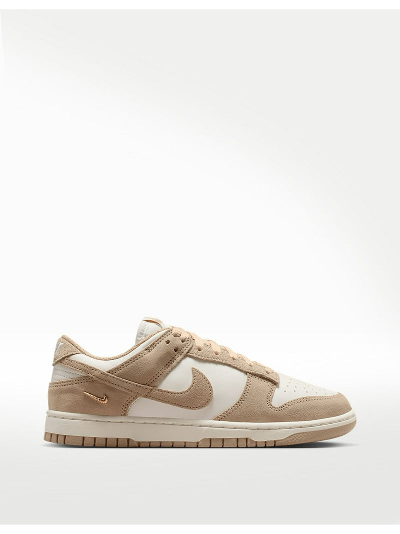 Tenis 𝐋𝐔𝐀𝐋 Nike Dunk Low en tonos arena y crema con cuero, gamuza y detalle de Swoosh metálico dorado.